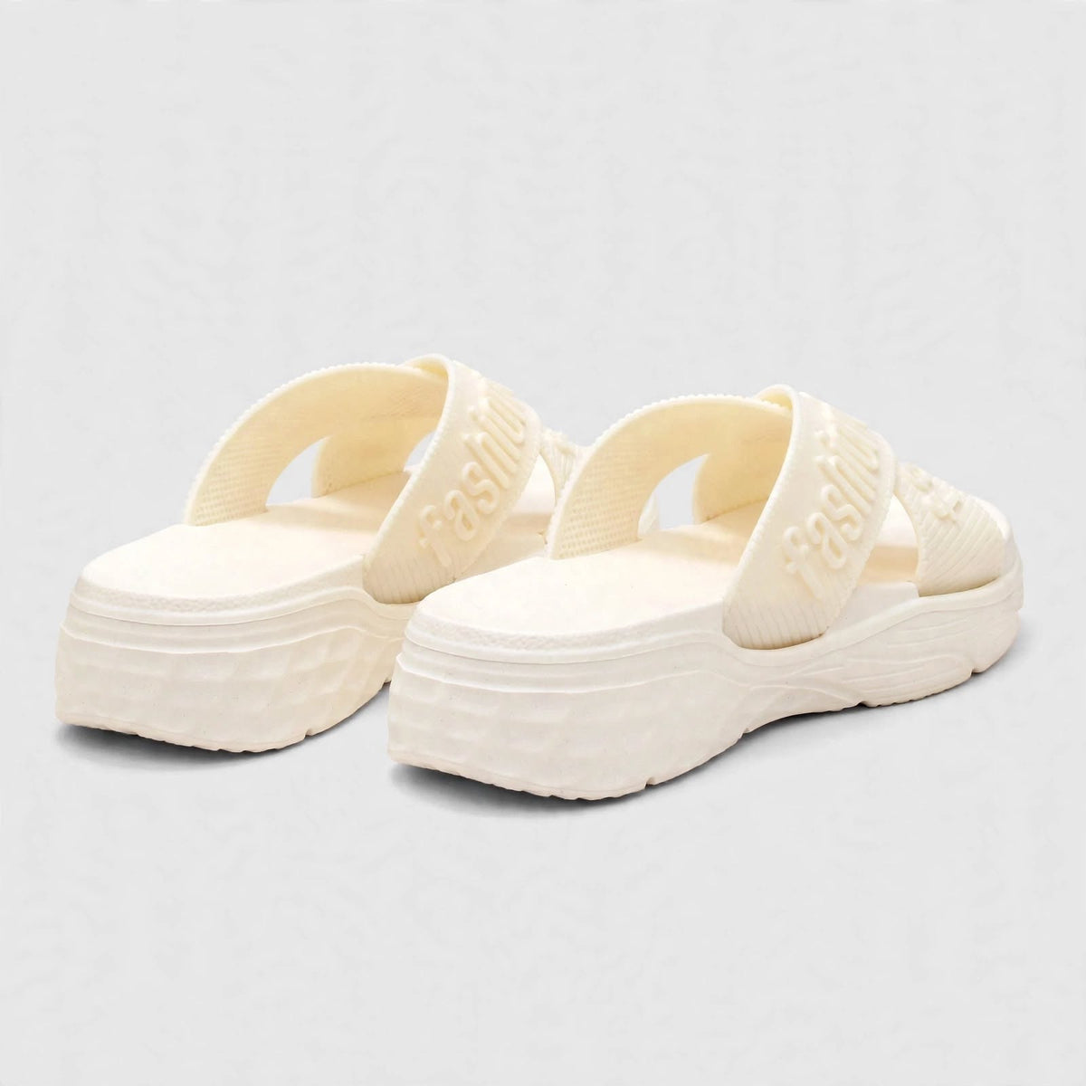 Pair of ivory slide sandals, angled studio shot