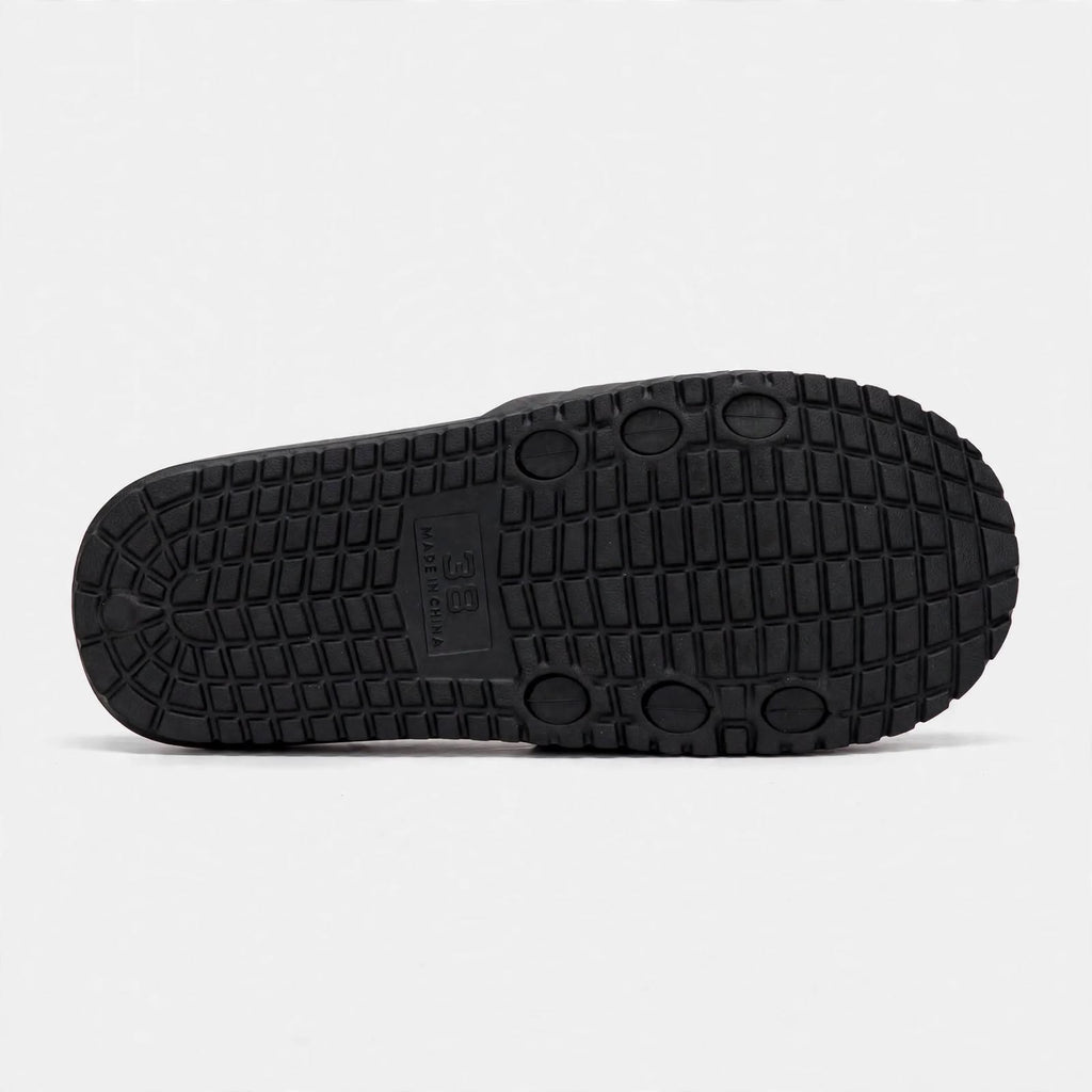 Matte black slide sandal outsole, bottom tread view
